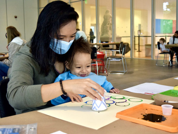 A woman and child complete an art activity.