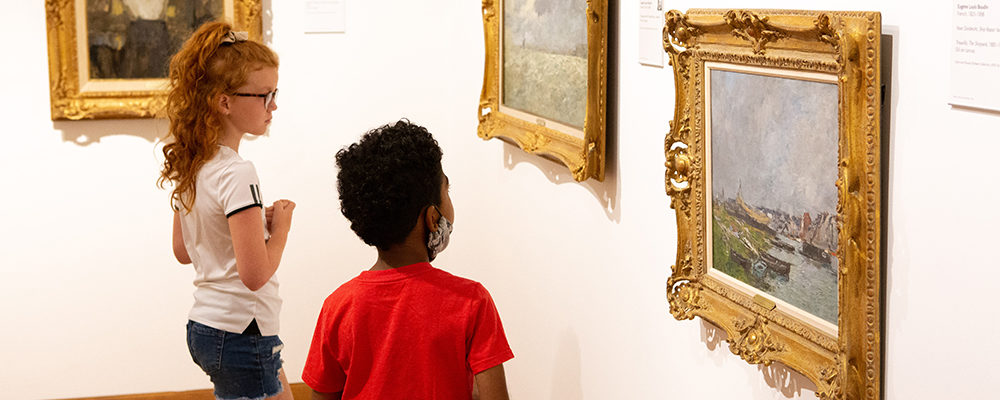 Two children look at a painting