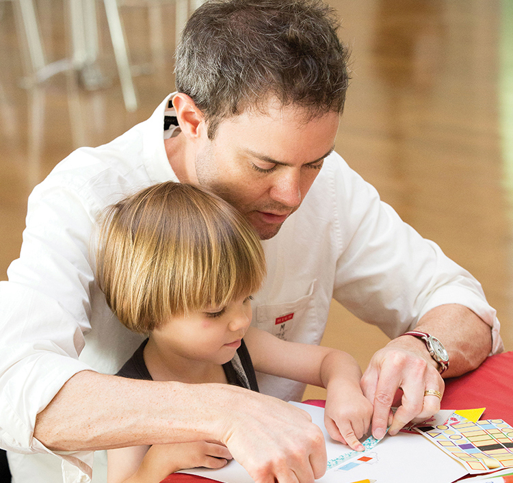 Parent helping child with art activity
