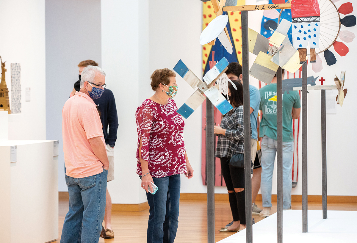 Visitors look at artwork in galleries