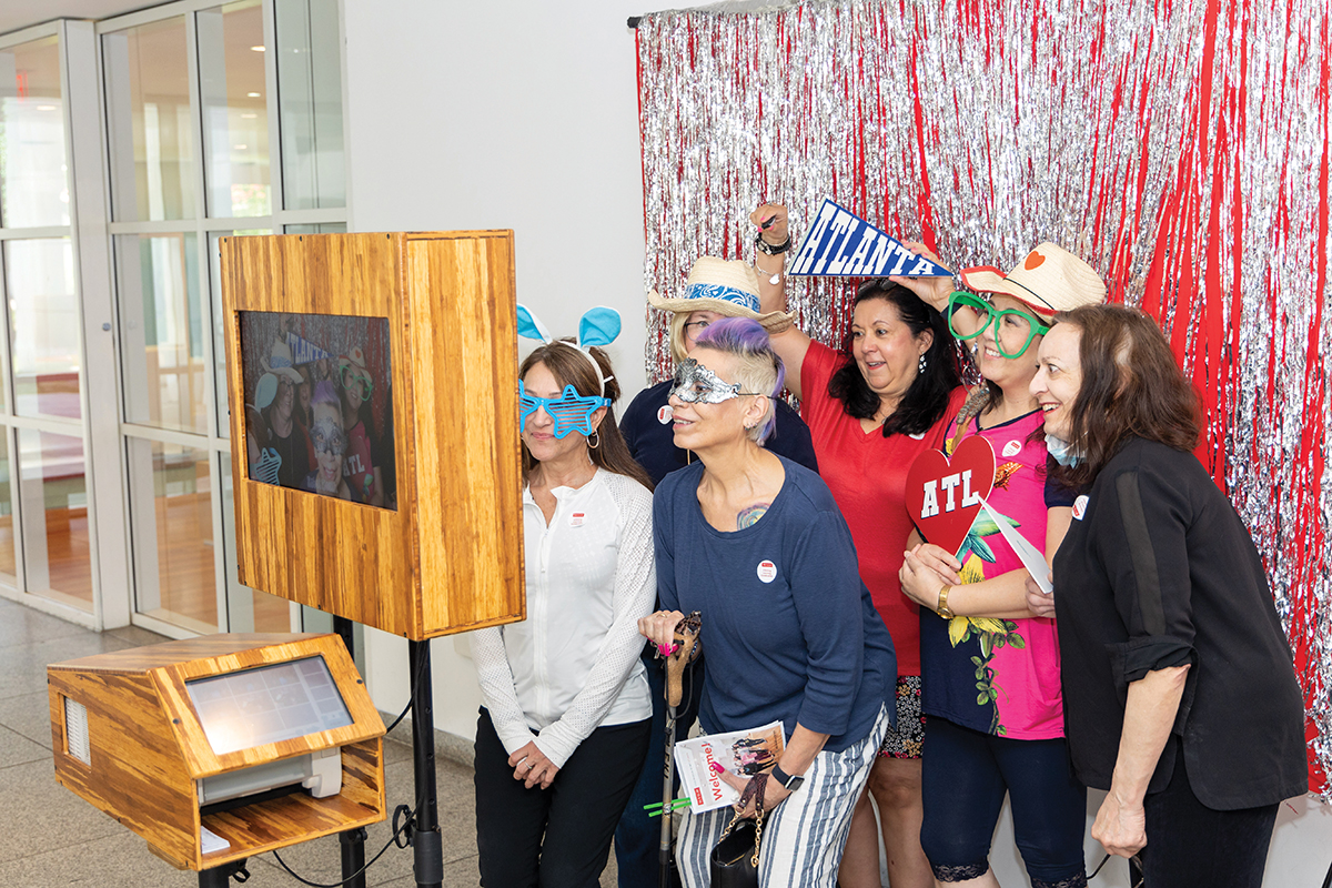 Visitors to the Lifelong Learning Celebration playfully pose in front of a photo booth.